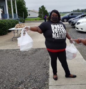 A Church member hands out food.